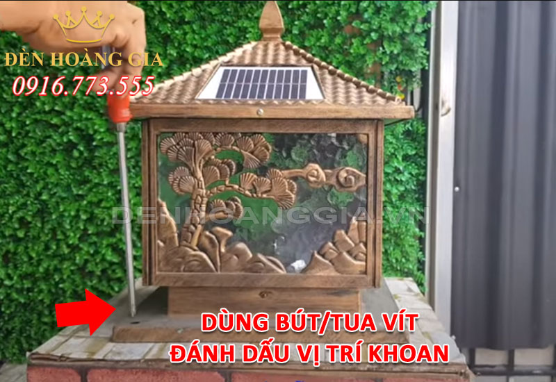 Dùng bút hoặc tua vít đánh dấu vị trí khoan lỗ lắp đèn trụ cổng