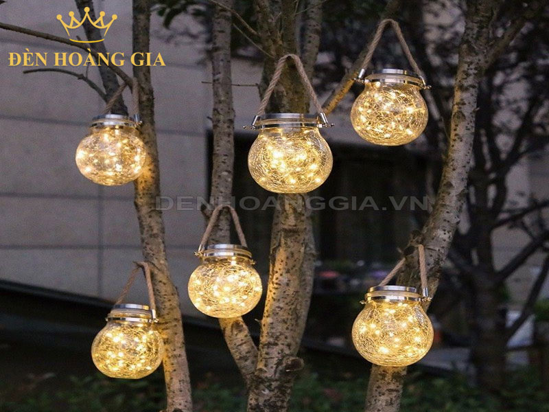 Decor sân vườn bằng cách treo một vài chiếc đèn lồng nhỏ trên thân cây